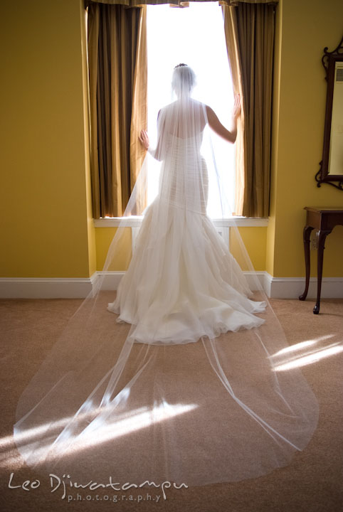 Bride posing by the window showing her long veil. The Tidewater Inn Wedding, Easton Maryland, getting ready photo coverage of Kelsey and Jonnie by wedding photographers of Leo Dj Photography.