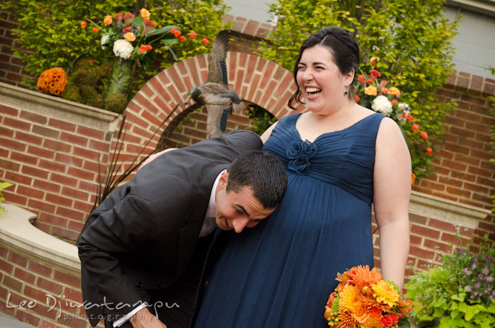 Groom listening to pregnant sister's belly. The Tidewater Inn Wedding, Easton Maryland, ceremony photo coverage of Kelsey and Jonnie by wedding photographers of Leo Dj Photography.