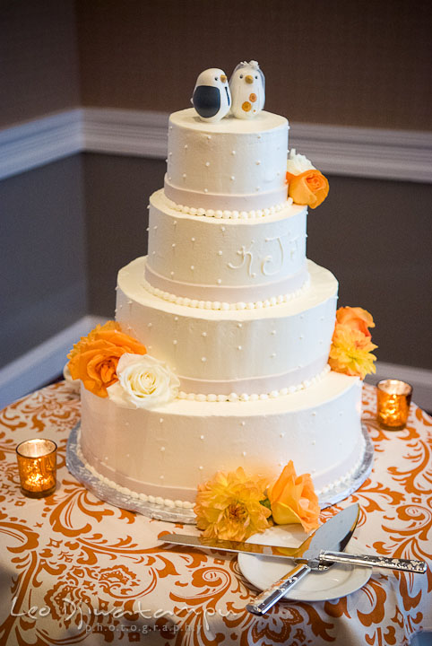 Four tier wedding cake with orange flowers. The Tidewater Inn Wedding, Easton Maryland, reception photo coverage of Kelsey and Jonnie by wedding photographers of Leo Dj Photography.