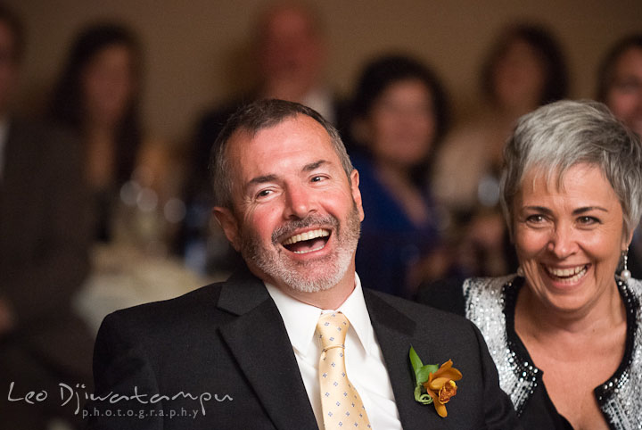 Father and mother of groom laughing during maid of honor's speech. The Tidewater Inn Wedding, Easton Maryland, reception photo coverage of Kelsey and Jonnie by wedding photographers of Leo Dj Photography.