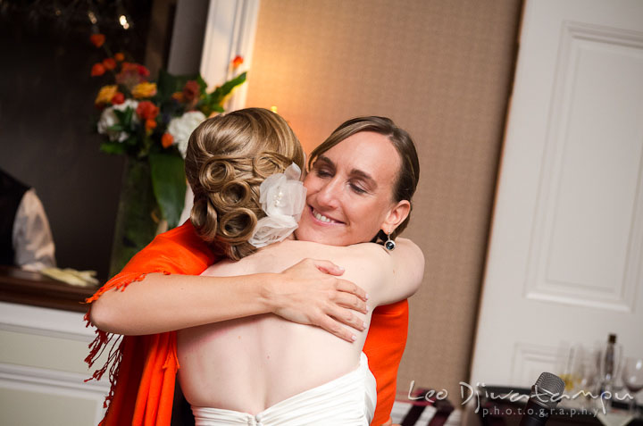 Bride hugged maid of honor after speech. The Tidewater Inn Wedding, Easton Maryland, reception photo coverage of Kelsey and Jonnie by wedding photographers of Leo Dj Photography.