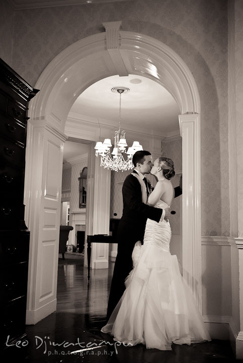 Bride and groom kissing under archway. The Tidewater Inn Wedding, Easton Maryland, reception photo coverage of Kelsey and Jonnie by wedding photographers of Leo Dj Photography.