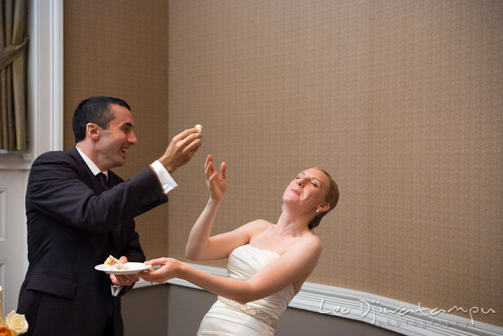 Groom trying to smush cake to bride. The Tidewater Inn Wedding, Easton Maryland, reception photo coverage of Kelsey and Jonnie by wedding photographers of Leo Dj Photography.