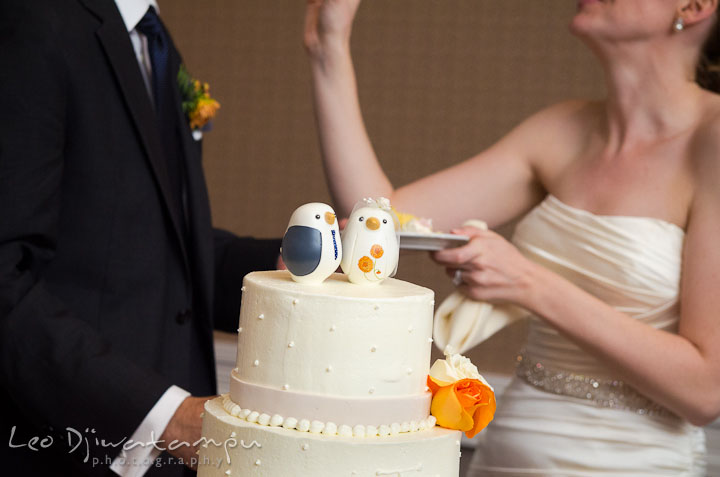 Wedding cake toppers with bride and groom in the background. The Tidewater Inn Wedding, Easton Maryland, reception photo coverage of Kelsey and Jonnie by wedding photographers of Leo Dj Photography.