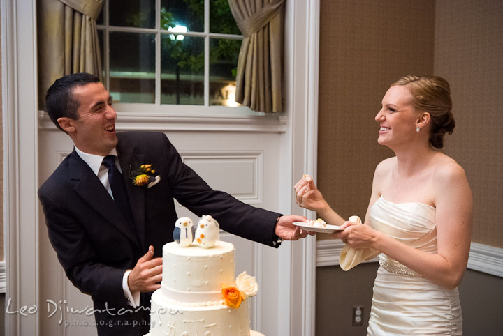 Groom trying to avoid bride smush more cake onto him. The Tidewater Inn Wedding, Easton Maryland, reception photo coverage of Kelsey and Jonnie by wedding photographers of Leo Dj Photography.