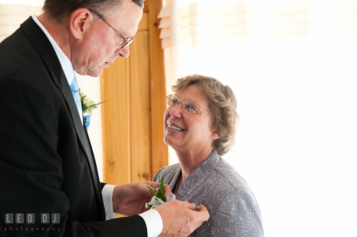 Father of the Bride putting on boutonniere on Mother of the Bride. Riverhouse Pavilion wedding photos at Easton, Eastern Shore, Maryland by photographers of Leo Dj Photography. http://leodjphoto.com