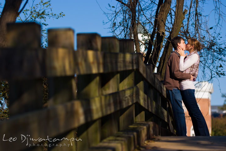 Engaged girl kissed her fiancé on the bridge. Pre-wedding engagement photo session at Washington College and Chestertown, Maryland, by wedding photographer Leo Dj Photography.