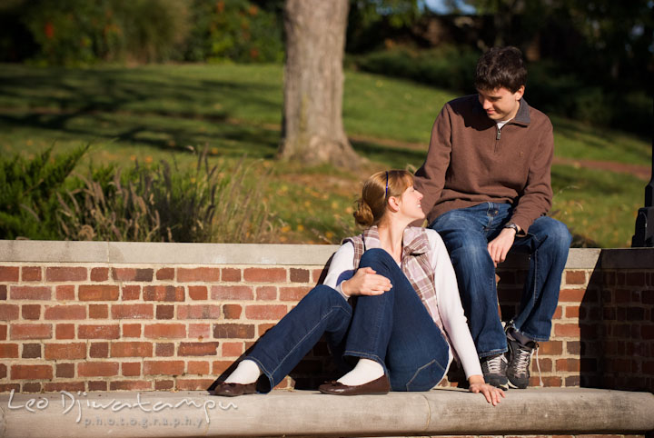 Engaged girl sitting and talking to her fiance. Pre-wedding engagement photo session at Washington College and Chestertown, Maryland, by wedding photographer Leo Dj Photography.