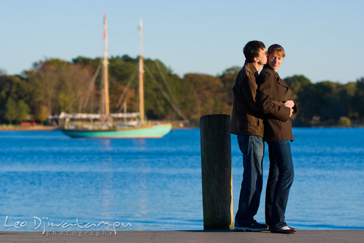 Engaged guy and girl hugging on a pier. Pre-wedding engagement photo session at Washington College and Chestertown, Maryland, by wedding photographer Leo Dj Photography.