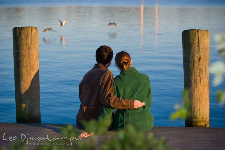 Engaged girl and her fiance enjoying the water view from the pier. Pre-wedding engagement photo session at Washington College and Chestertown, Maryland, by wedding photographer Leo Dj Photography.