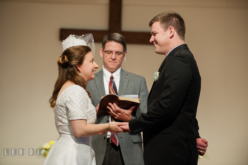 Bride putting ring on Grooms finger during exchange of rings. Fisherman's Inn, Safe Harbor Church, Kent Island, Eastern Shore Maryland, wedding reception and ceremony photo, by wedding photographers of Leo Dj Photography. http://leodjphoto.com