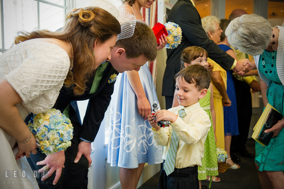 Ring bearer boy showing LEGO truck to Bride and Groom. Fisherman's Inn, Safe Harbor Church, Kent Island, Eastern Shore Maryland, wedding reception and ceremony photo, by wedding photographers of Leo Dj Photography. http://leodjphoto.com