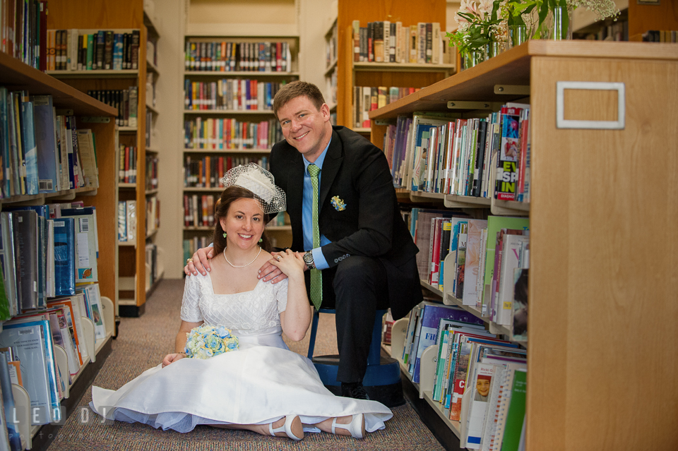 Bride and Groom posing by the books in the library. Fisherman's Inn, Safe Harbor Church, Kent Island, Eastern Shore Maryland, wedding reception and ceremony photo, by wedding photographers of Leo Dj Photography. http://leodjphoto.com