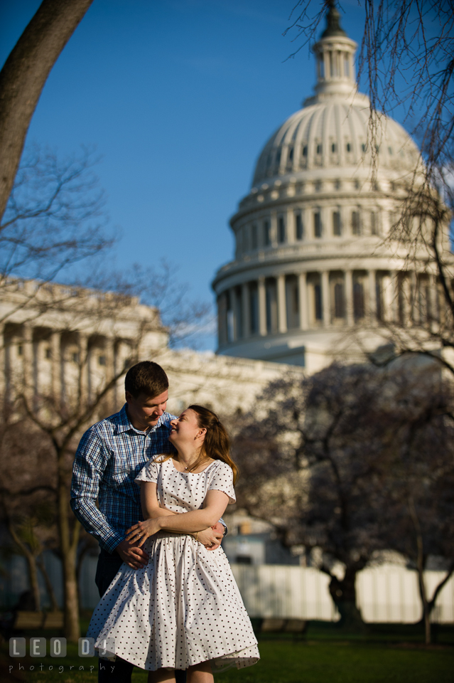 Engaged guy hugging his fiancée at the West lawn of the Capitol Hill . Washington DC pre-wedding engagement photo session at the Capitol Hill and the Mall, by wedding photographers of Leo Dj Photography. http://leodjphoto.com