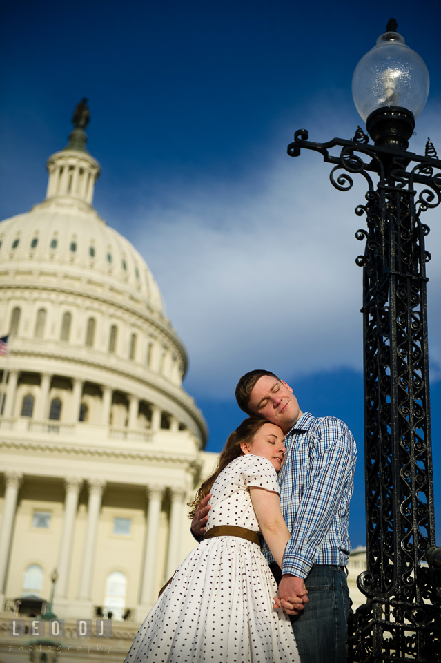 Engaged couple cuddling together in front of the Captiol Hill . Washington DC pre-wedding engagement photo session at the Capitol Hill and the Mall, by wedding photographers of Leo Dj Photography. http://leodjphoto.com