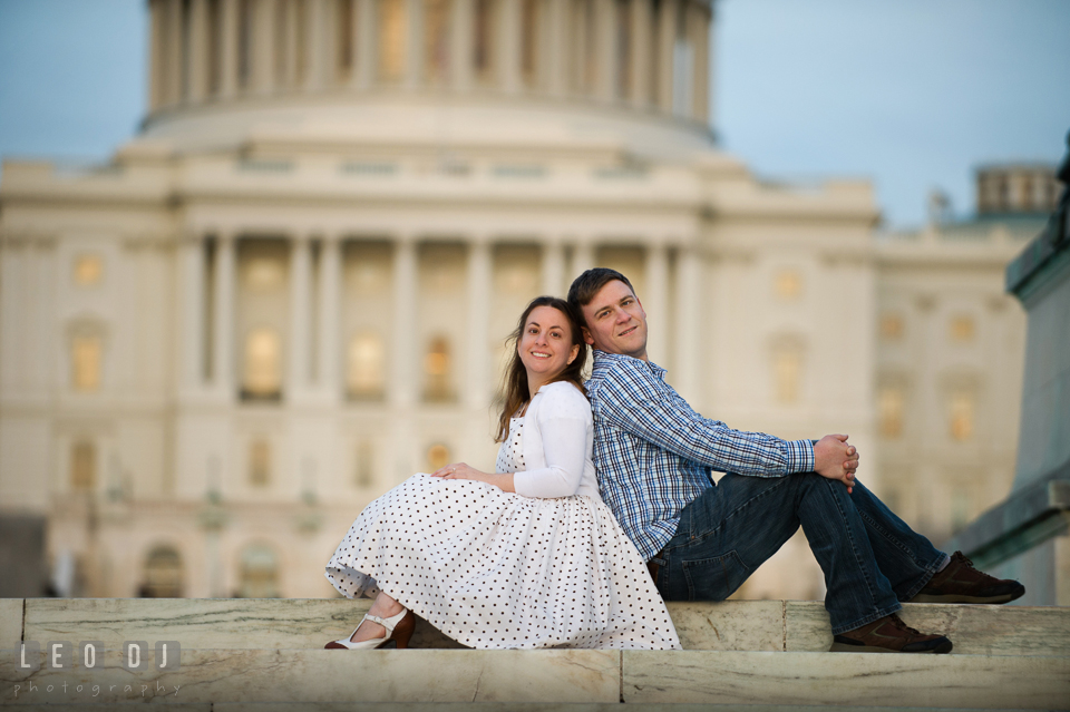 Engaged girl sitting back to back with her fiancé by the stairs at the Capitol Hill. Washington DC pre-wedding engagement photo session at the Capitol Hill and the Mall, by wedding photographers of Leo Dj Photography. http://leodjphoto.com