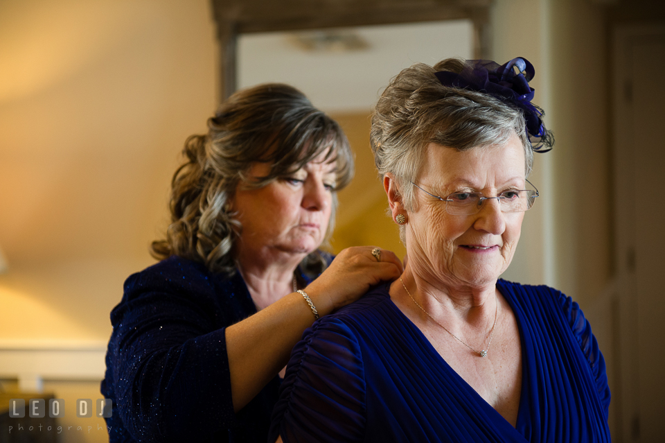 Mother of the Groom helping Mother of Bride putting on the necklace. Kent Island Maryland Chesapeake Bay Beach Club wedding photo, by wedding photographers of Leo Dj Photography. http://leodjphoto.com