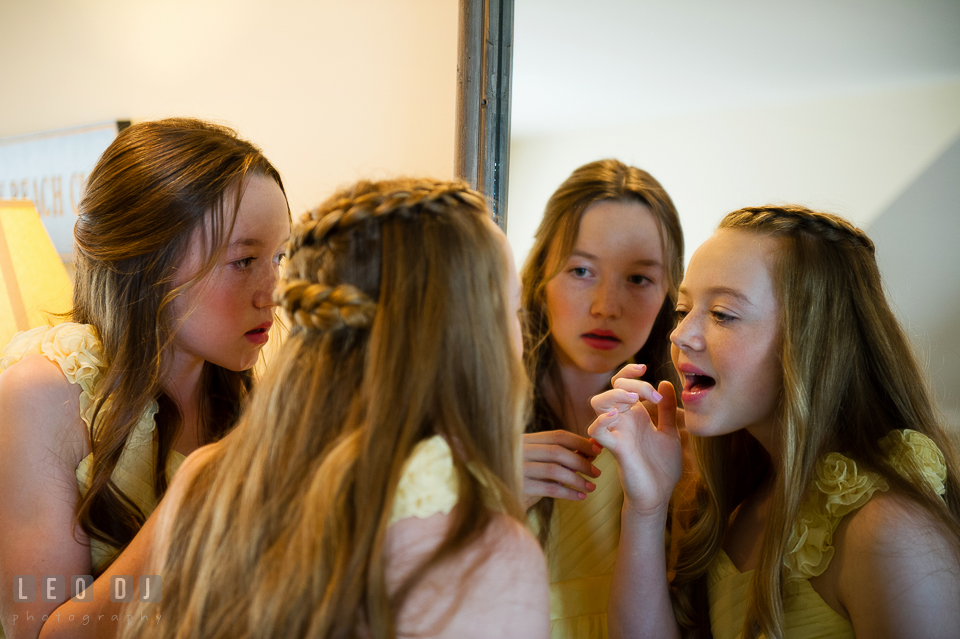 Two junior bridesmaids looking at the mirror checking their make up. Kent Island Maryland Chesapeake Bay Beach Club wedding photo, by wedding photographers of Leo Dj Photography. http://leodjphoto.com