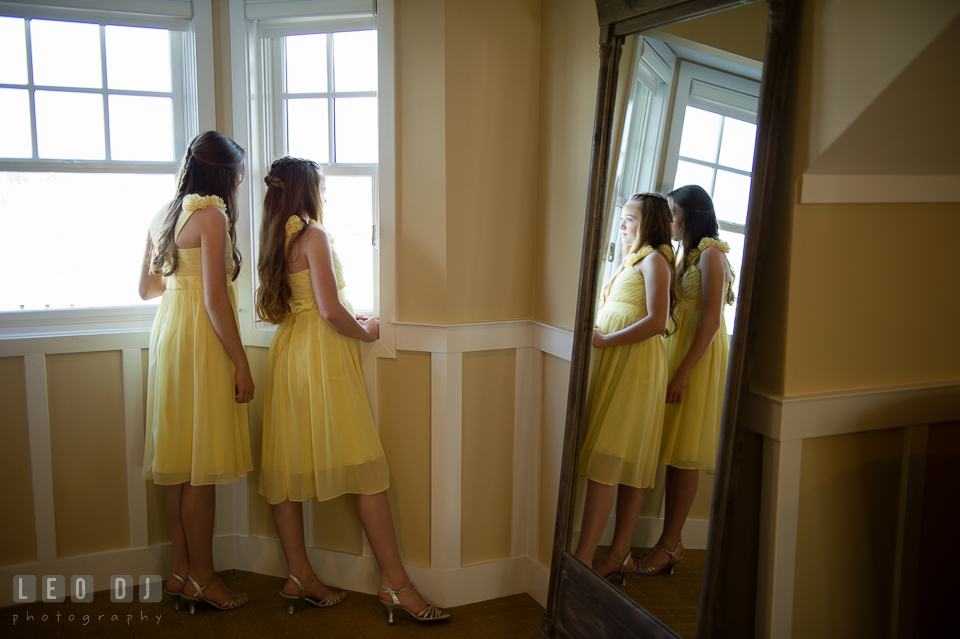 Two junior bridesmaids girls looking out at the window. Kent Island Maryland Chesapeake Bay Beach Club wedding photo, by wedding photographers of Leo Dj Photography. http://leodjphoto.com