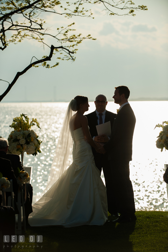 Silhouette of Bride and Groom during the ceremony with water in the background. Kent Island Maryland Chesapeake Bay Beach Club wedding photo, by wedding photographers of Leo Dj Photography. http://leodjphoto.com