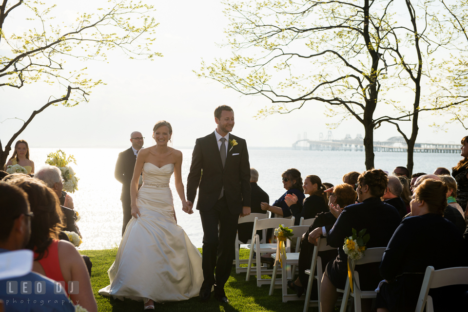 Bride and Groom holding hands walking out the aisle during processional. Kent Island Maryland Chesapeake Bay Beach Club wedding photo, by wedding photographers of Leo Dj Photography. http://leodjphoto.com