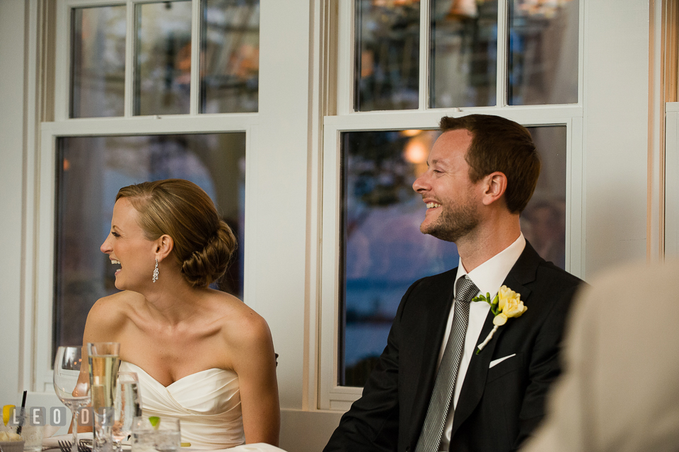 Bride and Groom at the sweetheart table laughing listening to toast speech. Kent Island Maryland Chesapeake Bay Beach Club wedding photo, by wedding photographers of Leo Dj Photography. http://leodjphoto.com