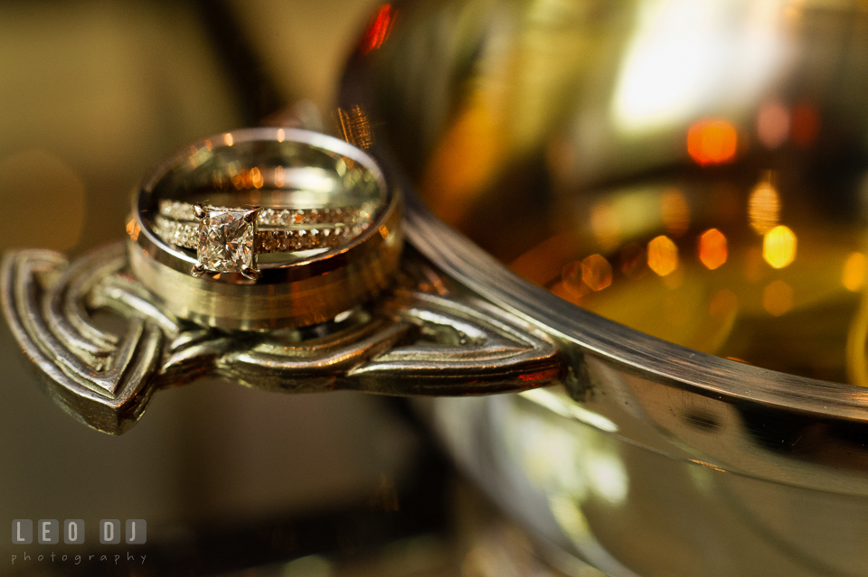 Bride's and Groom's diamond engagement ring and wedding bands on quaich cup. Kent Island Maryland Chesapeake Bay Beach Club wedding photo, by wedding photographers of Leo Dj Photography. http://leodjphoto.com