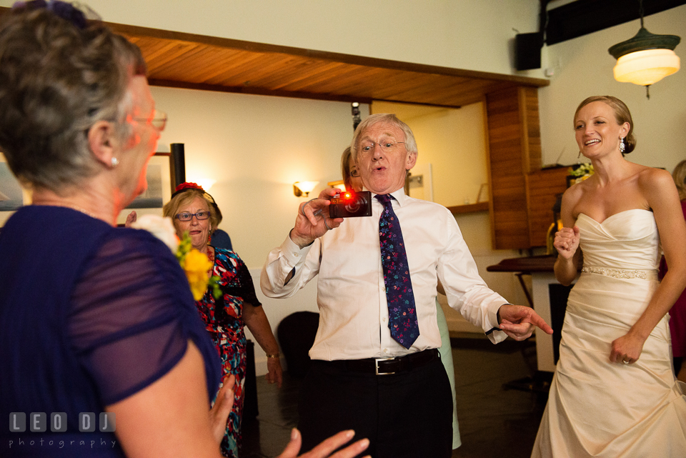 Uncle taking picture of Mother of Bride in a funny position. Kent Island Maryland Chesapeake Bay Beach Club wedding photo, by wedding photographers of Leo Dj Photography. http://leodjphoto.com