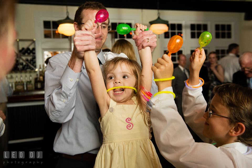 Little girl having fun dancing holding maracas and wearing glow sticks. Kent Island Maryland Chesapeake Bay Beach Club wedding photo, by wedding photographers of Leo Dj Photography. http://leodjphoto.com