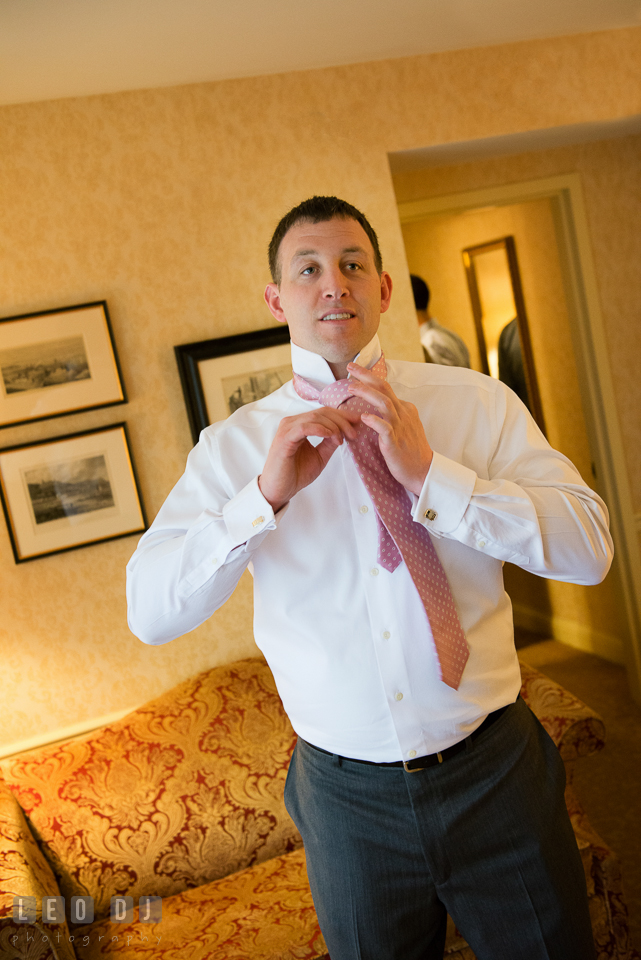 Groom putting on his tie. Historic Inns of Annapolis Maryland, Governor Calvert House wedding, by wedding photographers of Leo Dj Photography. http://leodjphoto.com