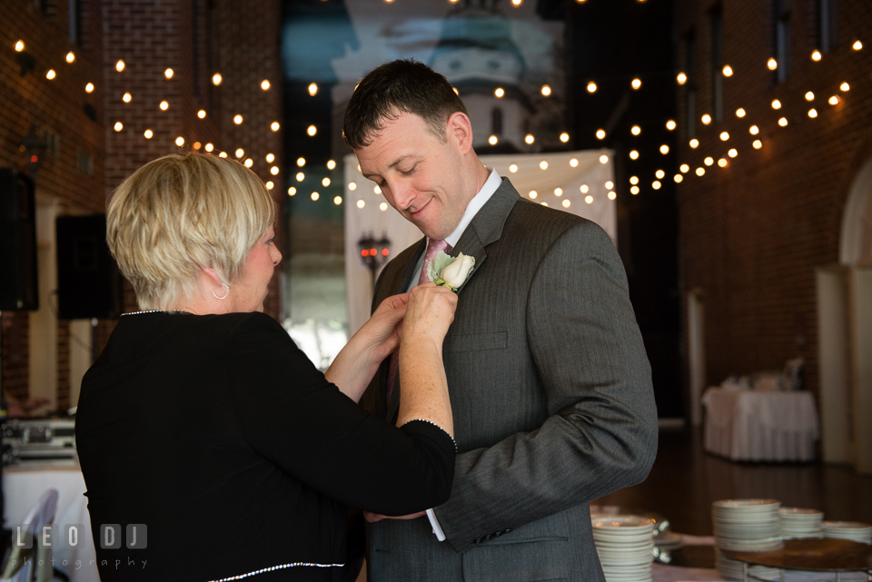 Mother of Groom putting on boutonniere on her son's jacket. Historic Inns of Annapolis Maryland, Governor Calvert House wedding, by wedding photographers of Leo Dj Photography. http://leodjphoto.com