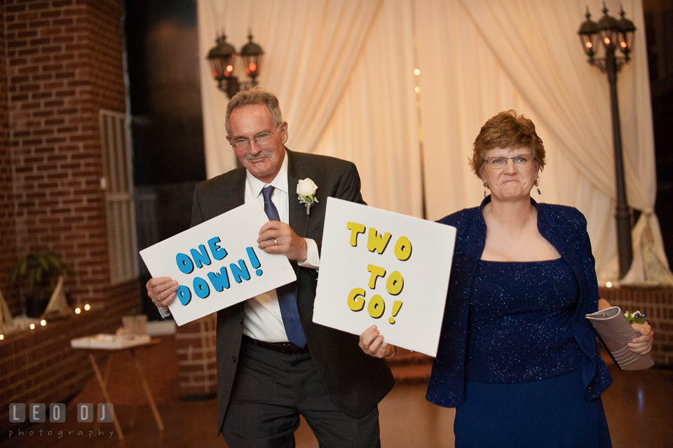 Mother and Father of Bride during the introduction holding signs of One Down, Two to Go. Historic Inns of Annapolis Maryland, Governor Calvert House wedding, by wedding photographers of Leo Dj Photography. http://leodjphoto.com