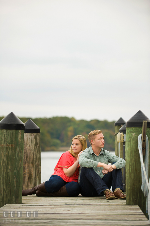 Engaged couple sitting on a boat dock enjoying the beautiful view. Chestertown Eastern Shore Maryland pre-wedding engagement photo session by the water, by wedding photographers of Leo Dj Photography. http://leodjphoto.com