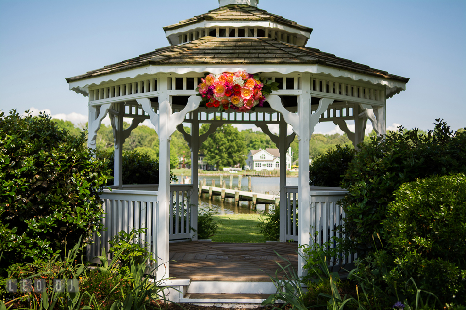 Bold and vibrant colored peonies, roses, gerberas, and proteas flower decor on gazebo designed by Intrigue Design and Decor. Kent Manor Inn, Kent Island, Eastern Shore Maryland, wedding ceremony and getting ready photos, by wedding photographers of Leo Dj Photography. http://leodjphoto.com