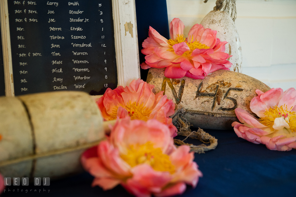 Table seating assignment chart with large pink peonies flowers and fish net floats. Kent Manor Inn, Kent Island, Eastern Shore Maryland, wedding reception and ceremony photo, by wedding photographers of Leo Dj Photography. http://leodjphoto.com