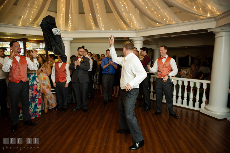 Groom threw jacket to Best Man before getting garter from Bride. Kent Manor Inn, Kent Island, Eastern Shore Maryland, wedding reception and ceremony photo, by wedding photographers of Leo Dj Photography. http://leodjphoto.com