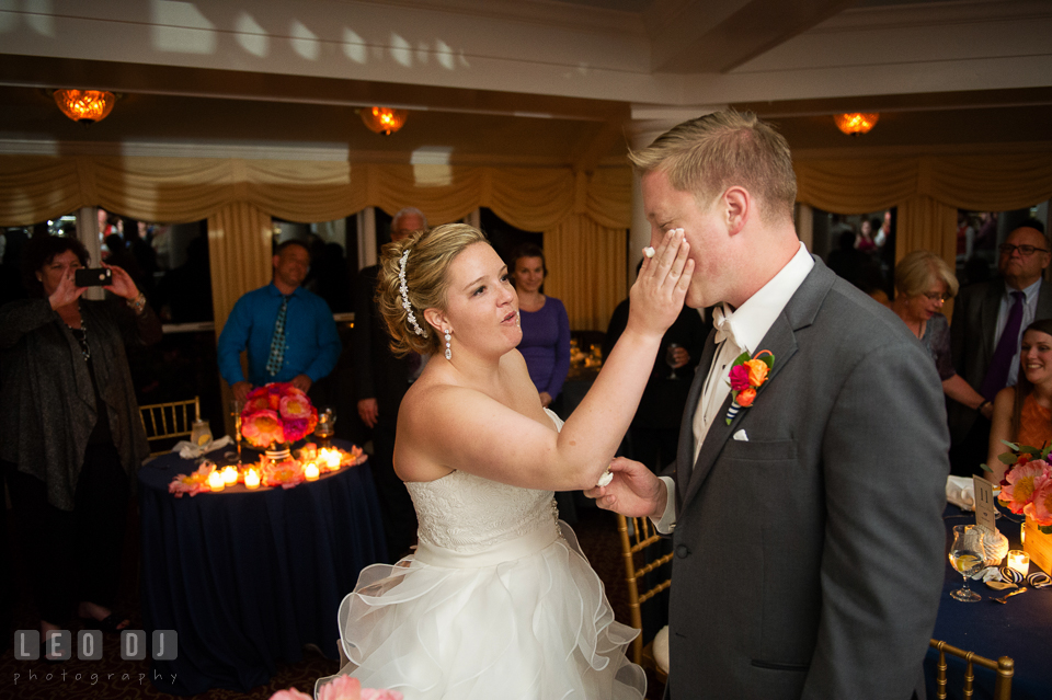 Bride slapped cake icing on Groom's cheek during cake cutting. Kent Manor Inn, Kent Island, Eastern Shore Maryland, wedding reception and ceremony photo, by wedding photographers of Leo Dj Photography. http://leodjphoto.com