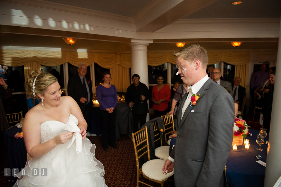 Bride and guests laughed seeing Groom with icing on his face after cake cutting. Kent Manor Inn, Kent Island, Eastern Shore Maryland, wedding reception and ceremony photo, by wedding photographers of Leo Dj Photography. http://leodjphoto.com