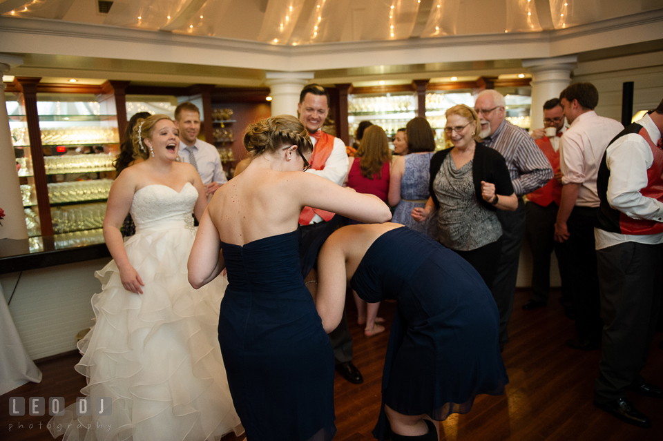 Bride laughing seeing bridesmaids doing silly stuff during dancing. Kent Manor Inn, Kent Island, Eastern Shore Maryland, wedding reception and ceremony photo, by wedding photographers of Leo Dj Photography. http://leodjphoto.com