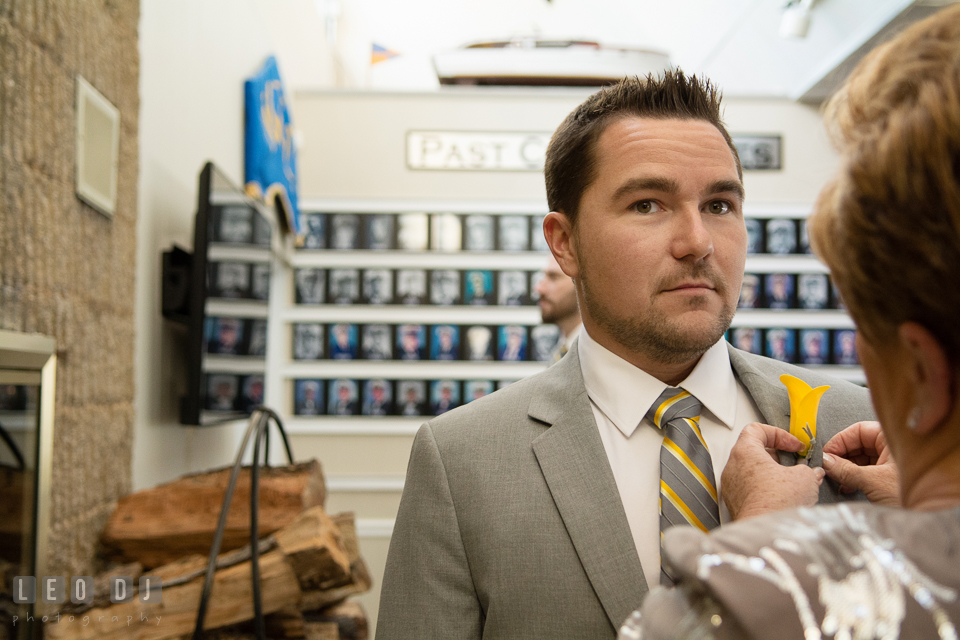 Mother of the Groom putting on the boutonniere on her son. Maryland Yacht Club wedding at Pasadena Maryland, by wedding photographers of Leo Dj Photography. http://leodjphoto.com