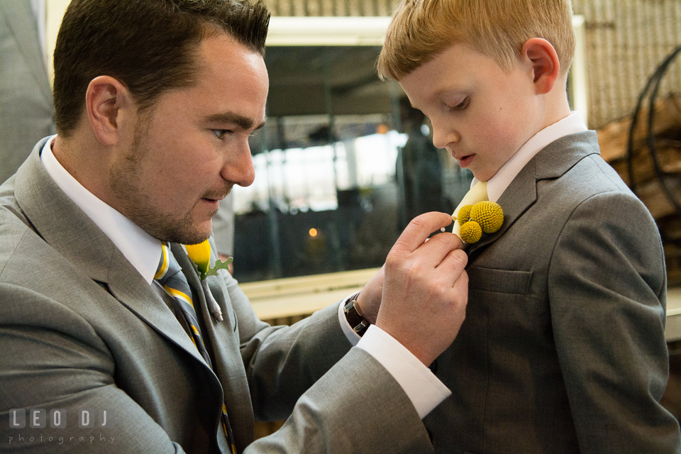 Groom putting on boutonniere on the ring bearer boy. Maryland Yacht Club wedding at Pasadena Maryland, by wedding photographers of Leo Dj Photography. http://leodjphoto.com