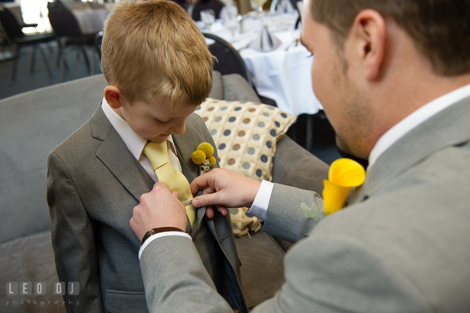 Groom put tie clip for the ring bearer boy. Maryland Yacht Club wedding at Pasadena Maryland, by wedding photographers of Leo Dj Photography. http://leodjphoto.com