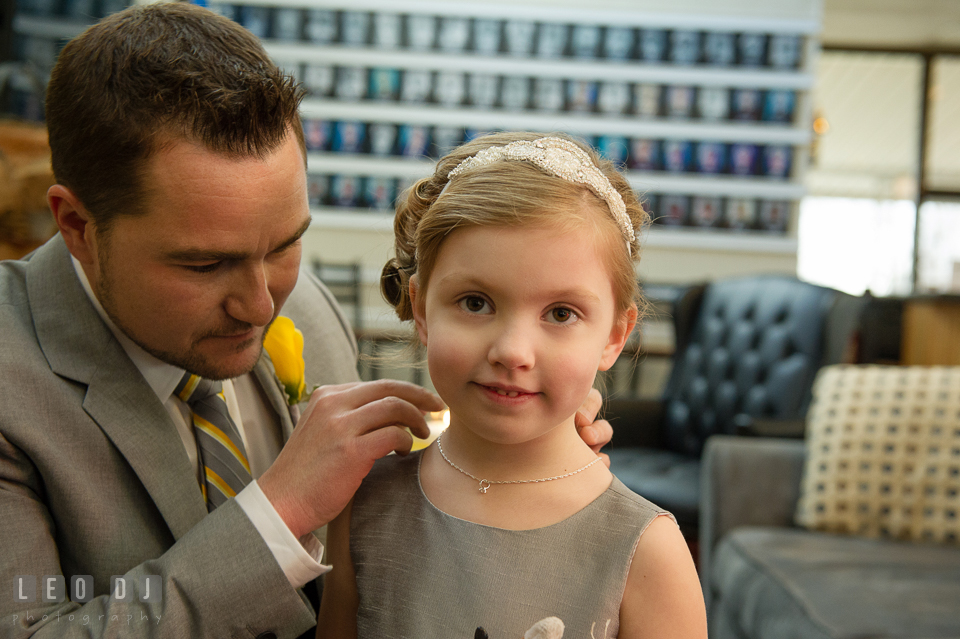 Groom putting on necklace gift around flower girl's neck. Maryland Yacht Club wedding at Pasadena Maryland, by wedding photographers of Leo Dj Photography. http://leodjphoto.com