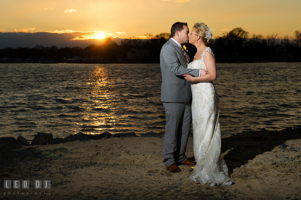 Bride and Groom kissing by the water during sunset. Maryland Yacht Club wedding at Pasadena Maryland, by wedding photographers of Leo Dj Photography. http://leodjphoto.com