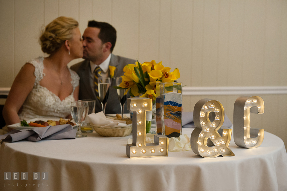 Bride and Groom kissing behind their sweetheart table. Maryland Yacht Club wedding at Pasadena Maryland, by wedding photographers of Leo Dj Photography. http://leodjphoto.com