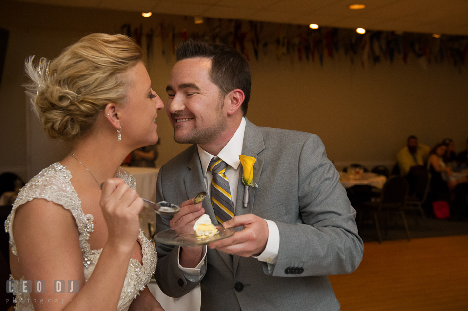 Bride and Groom kissing and feeding cake to each other. Maryland Yacht Club wedding at Pasadena Maryland, by wedding photographers of Leo Dj Photography. http://leodjphoto.com