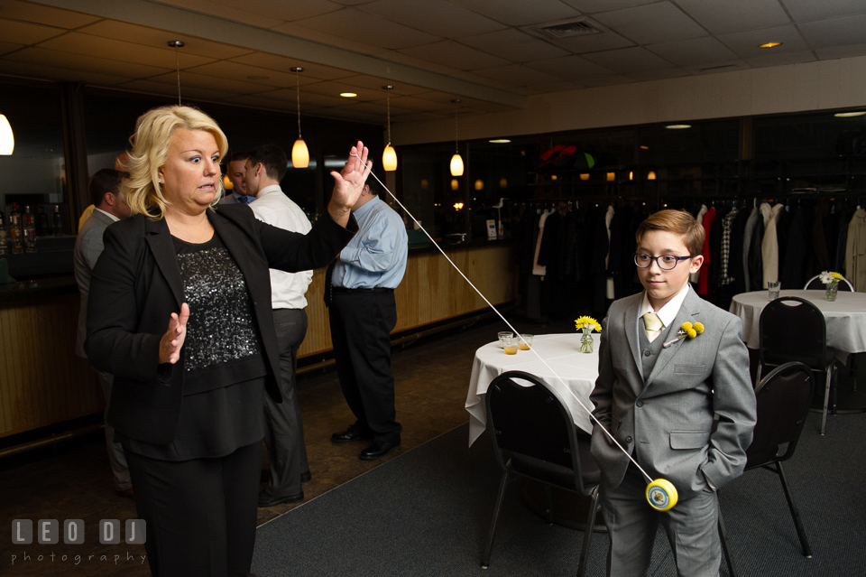 Ring bearer boy watching her aunt playing yo-yo. Maryland Yacht Club wedding at Pasadena Maryland, by wedding photographers of Leo Dj Photography. http://leodjphoto.com