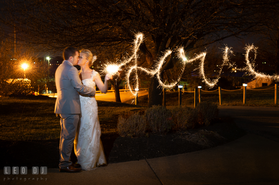 Bride and Groom kissing with sparklers writing Love. Maryland Yacht Club wedding at Pasadena Maryland, by wedding photographers of Leo Dj Photography. http://leodjphoto.com