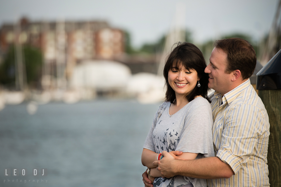 Engaged man at the dock hugging his fiancée from behind. Annapolis Eastern Shore Maryland pre-wedding engagement photo session at downtown, by wedding photographers of Leo Dj Photography. http://leodjphoto.com