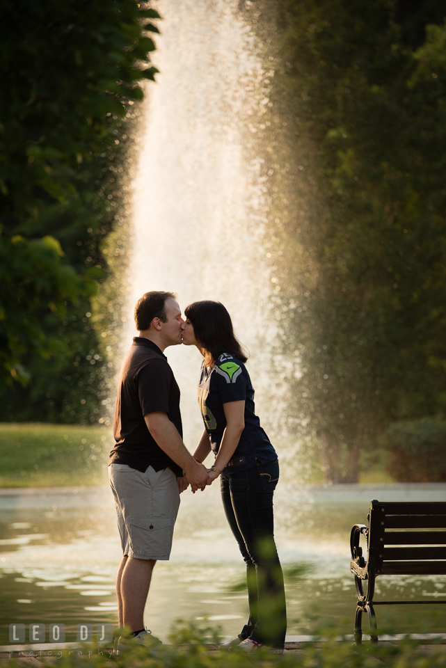 Engaged girl kissing her fiance by the fountain. Quiet Waters Park Annapolis Maryland pre-wedding engagement photo session, by wedding photographers of Leo Dj Photography. http://leodjphoto.com